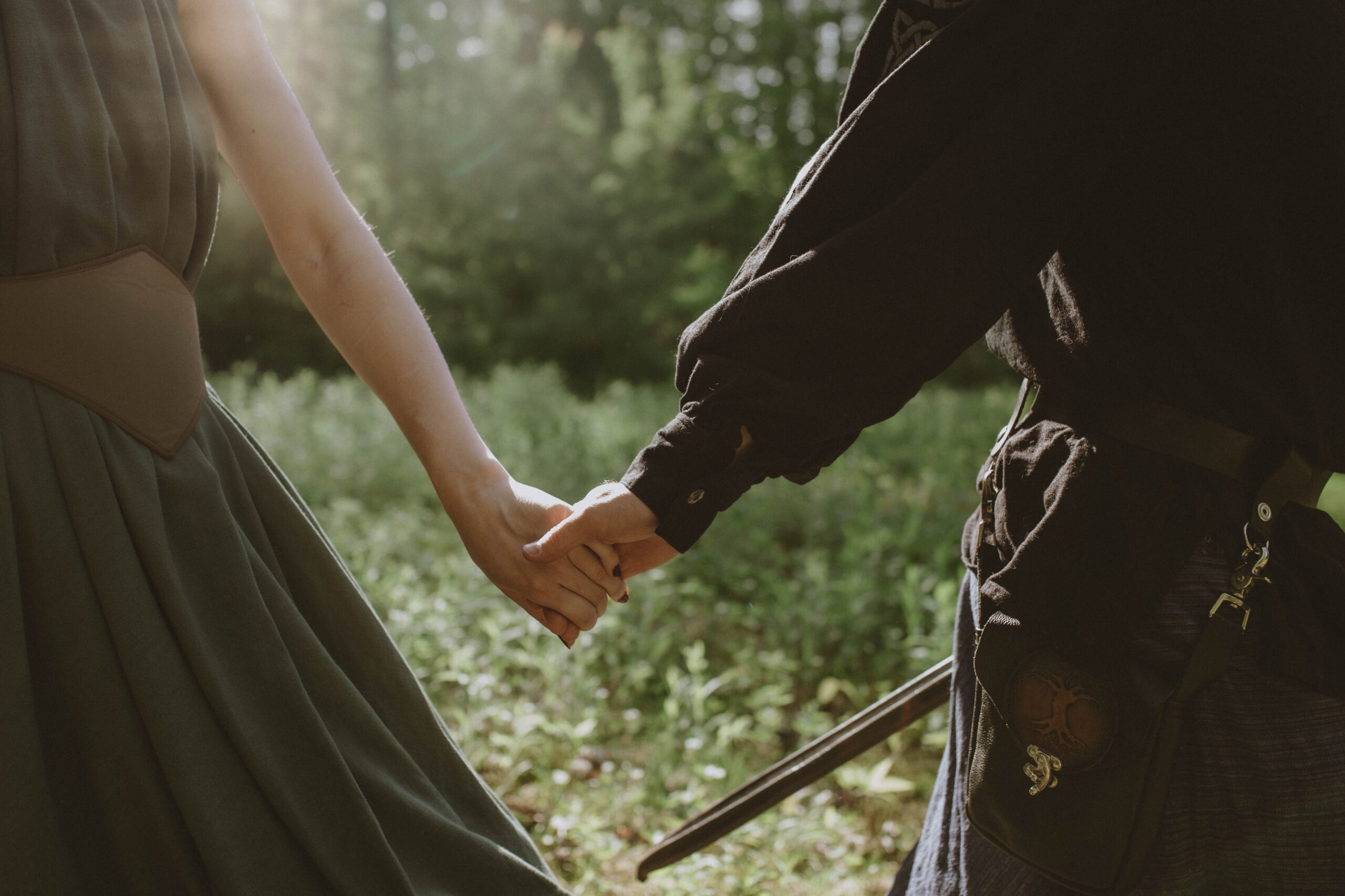 A closeup of a man and woman's hands during their White Mountains high fantasy engagement session